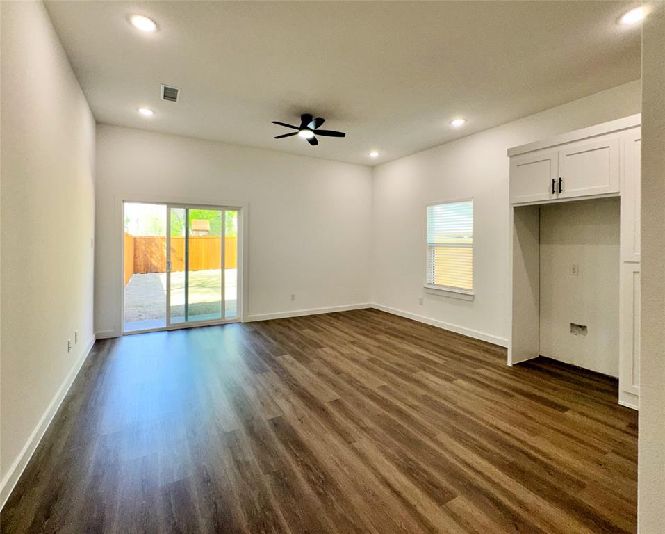 1811 Washington Street Commerce, TX 75428 - Photo 16 of 36 an empty room with wooden floor and windows