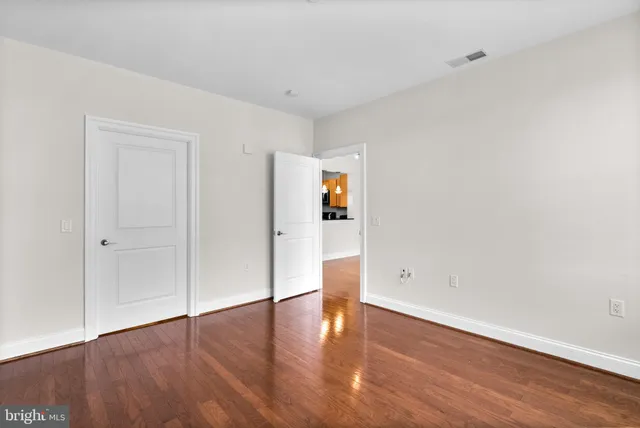 a view of an empty room with wooden floor