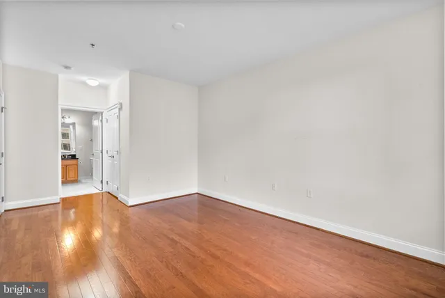 a view of an empty room with wooden floor