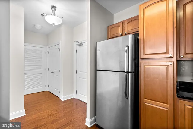 a kitchen with stainless steel appliances refrigerator and wooden floor