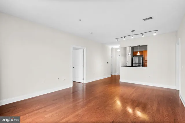 an empty room with wooden floor and window