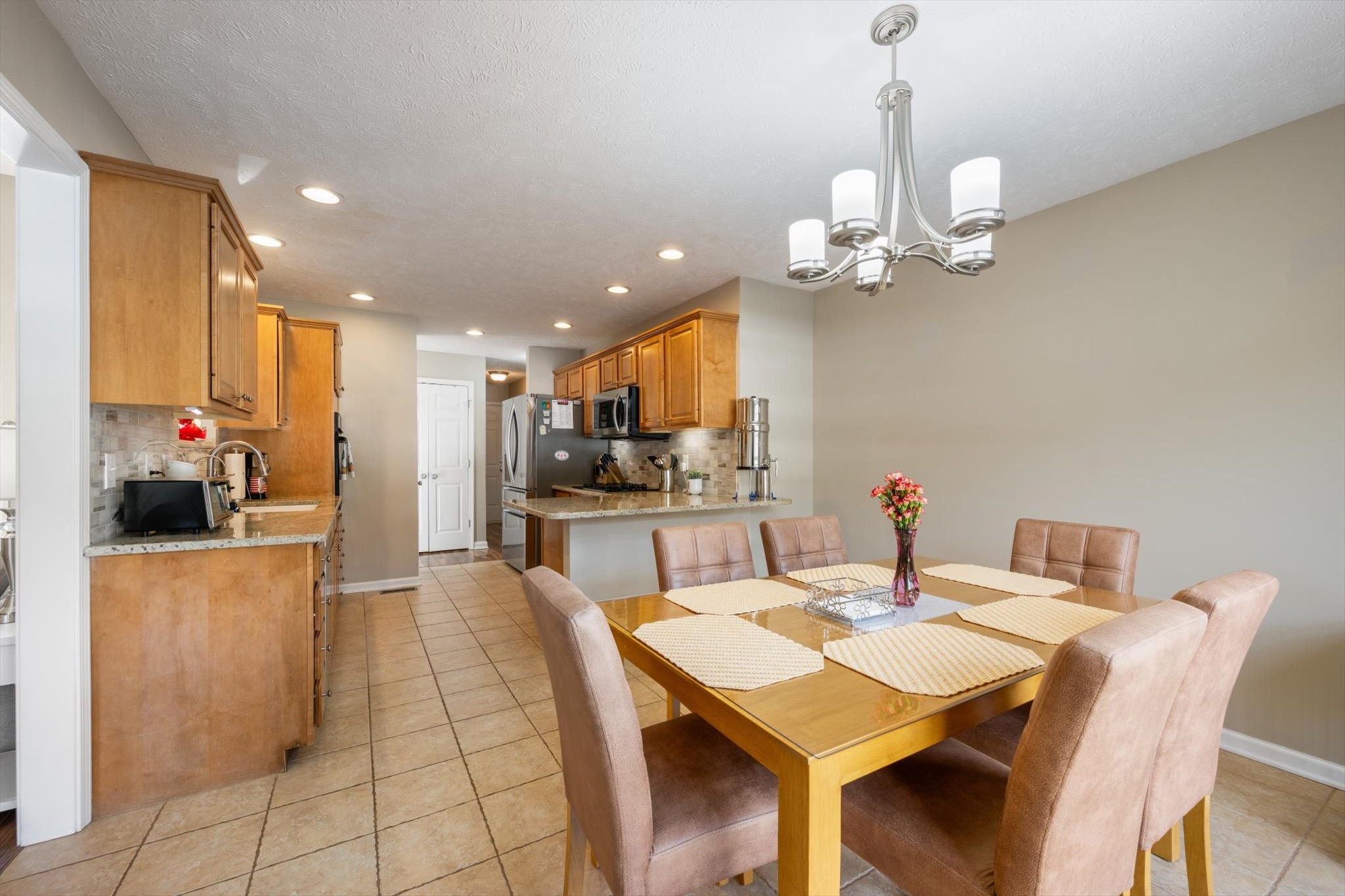 560 Windy Road Mount Juliet, TN 37122 - Photo 10 of 40 a view of a dining room and a kitchen with a table chairs and chandelier