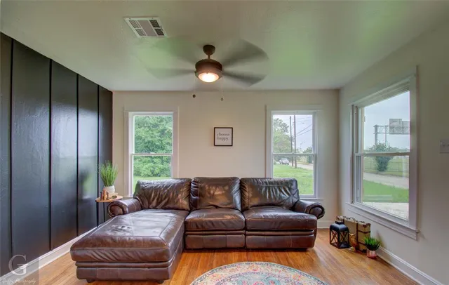 a living room with furniture ceiling fan and a window