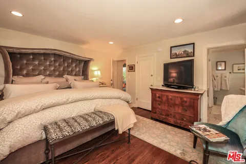 a bedroom with a bed and a flat screen tv