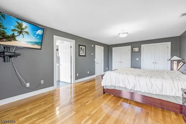 a spacious bedroom with a bed and a painting on the wall
