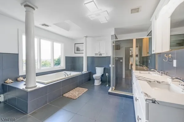 a bathroom with a tub sink and mirror