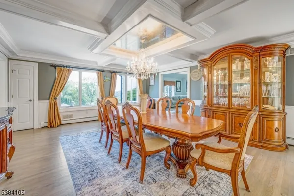 a dining room with furniture a chandelier and wooden floor