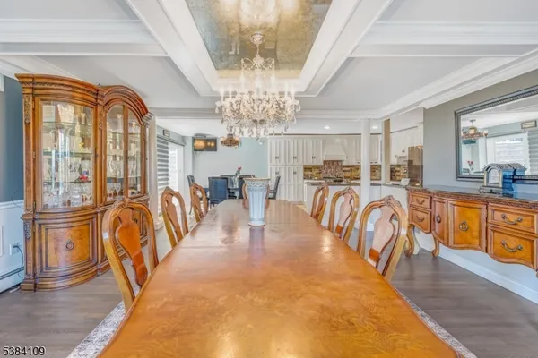 a view of a dining room with furniture a chandelier and wooden floor