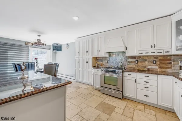 a kitchen with granite countertop white cabinets white appliances and sink
