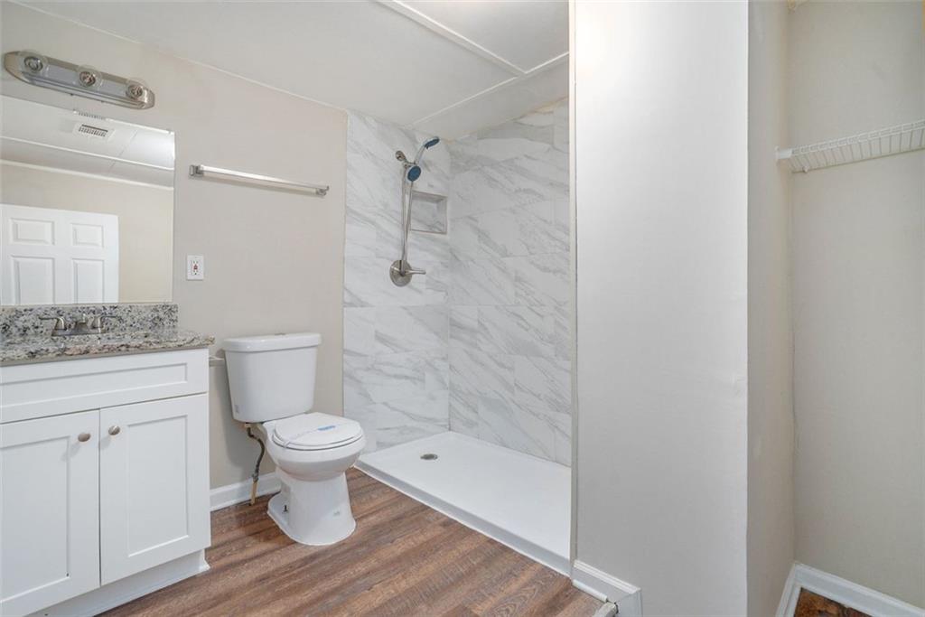 1714 Camperdown Circle Decatur, GA 30035 - Photo 15 of 15 a bathroom with a granite countertop toilet a sink and a shower