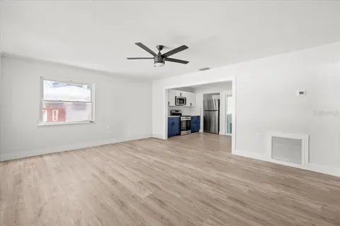 a view of empty room with wooden floor and ceiling fan