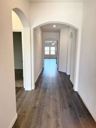 a view of a hallway with wooden floor