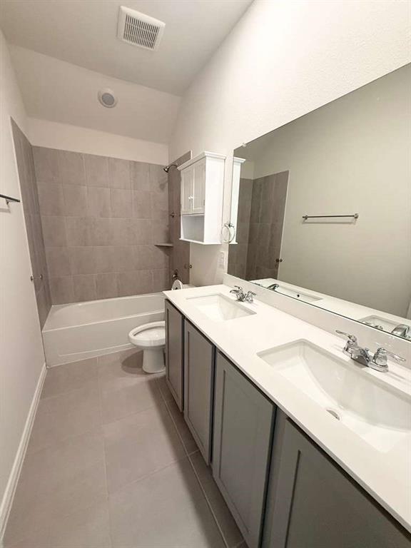 804 Marigold Street Princeton, TX 75407 - Photo 4 of 19 Bathroom featuring bathing tub / shower combination, double vanity, lofted ceiling, and light tile patterned flooring