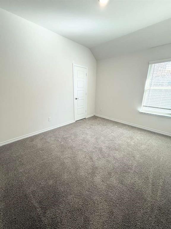 804 Marigold Street Princeton, TX 75407 - Photo 5 of 19 Spare room featuring carpet floors and vaulted ceiling