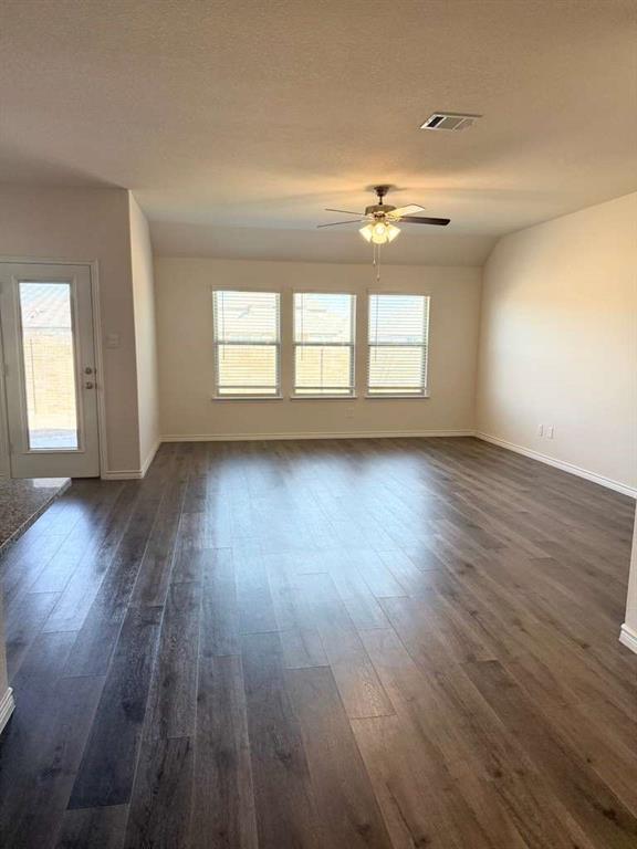 804 Marigold Street Princeton, TX 75407 - Photo 7 of 19 Unfurnished room with dark wood-type flooring, ceiling fan, and a textured ceiling