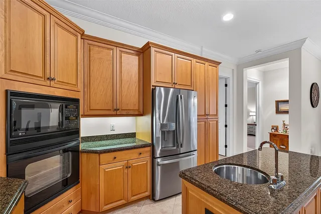 a kitchen with granite countertop a refrigerator stove and sink