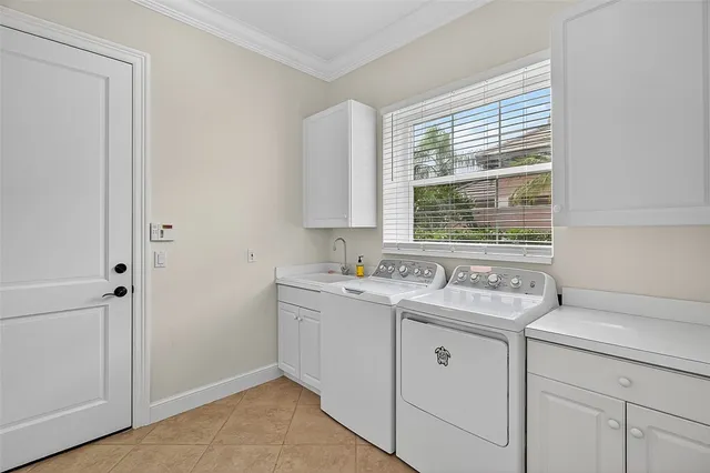 a utility room with cabinets washer and dryer
