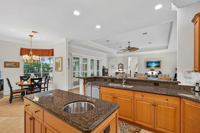 a kitchen with stainless steel appliances granite countertop a sink a stove and a wooden cabinets