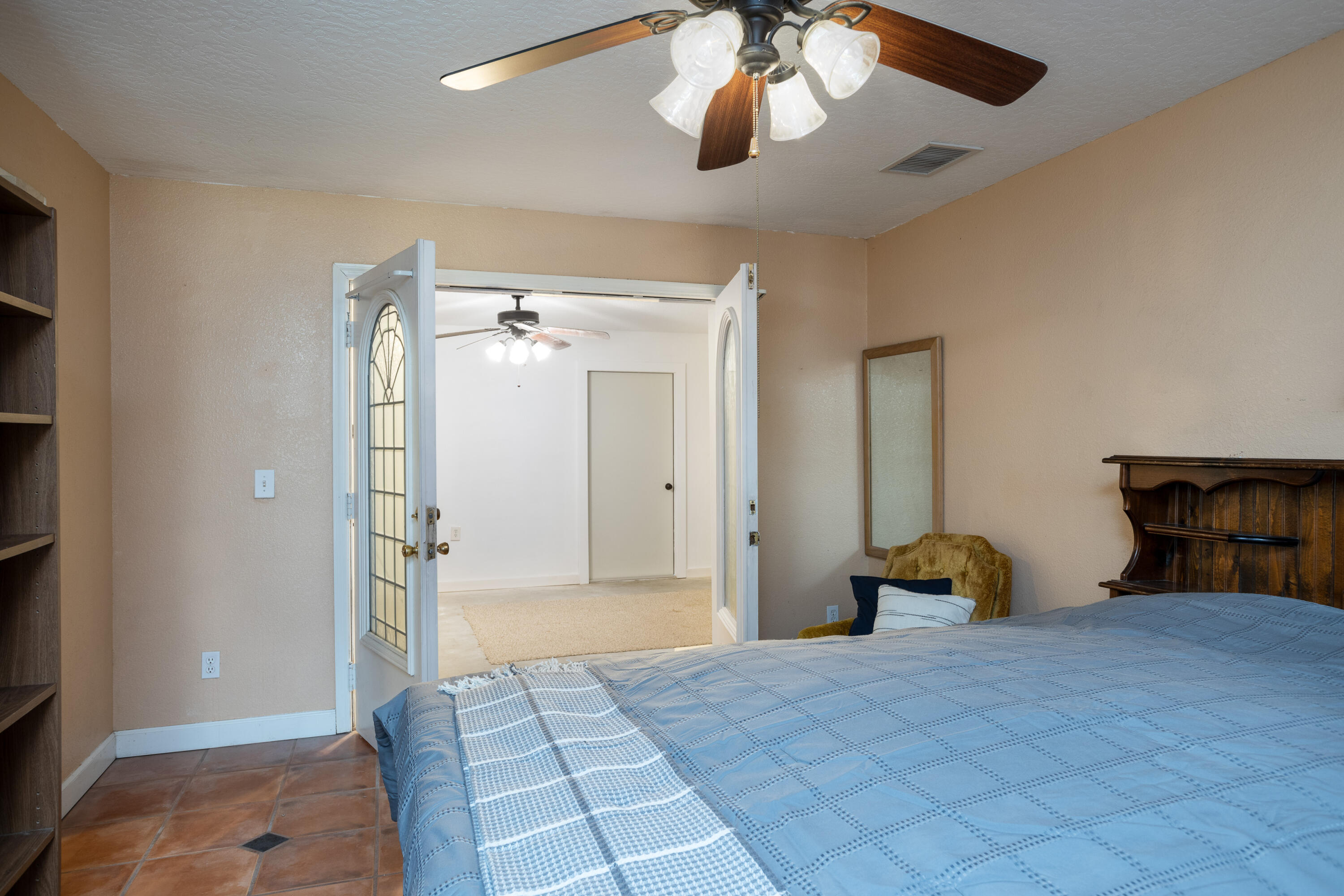 1280 Corey Road Malabar, FL 32950 - Photo 21 of 56 a bedroom with a bed and a chandelier