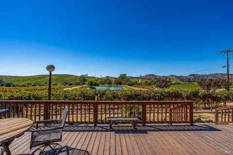 a view of a balcony with wooden floor and fence