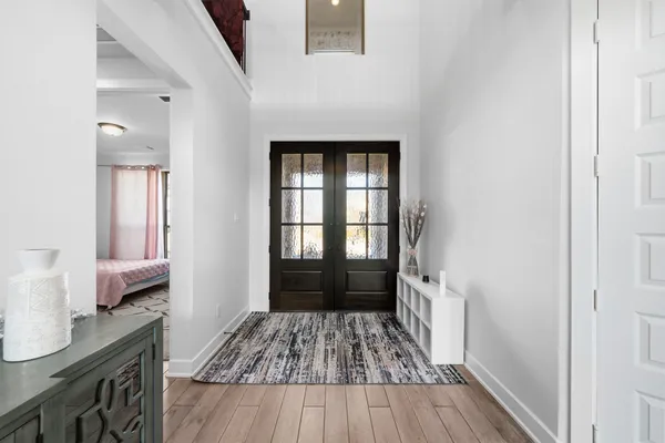 a view of a hallway view with wooden floor and a bathroom