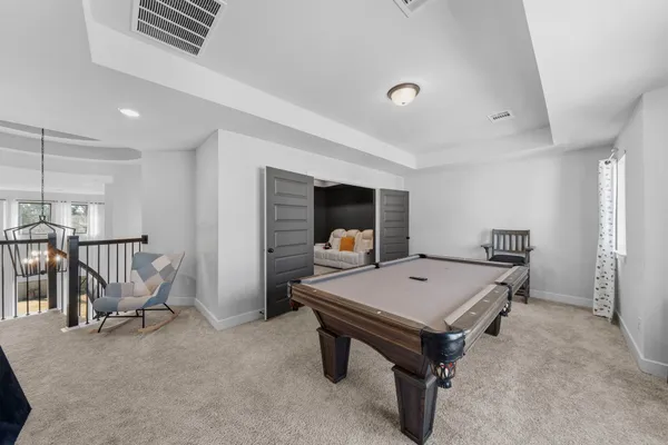 a living room with furniture pool table and window