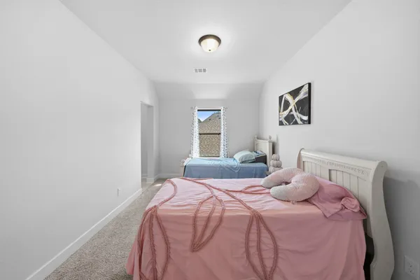 a bedroom with a bed and painting on the wall