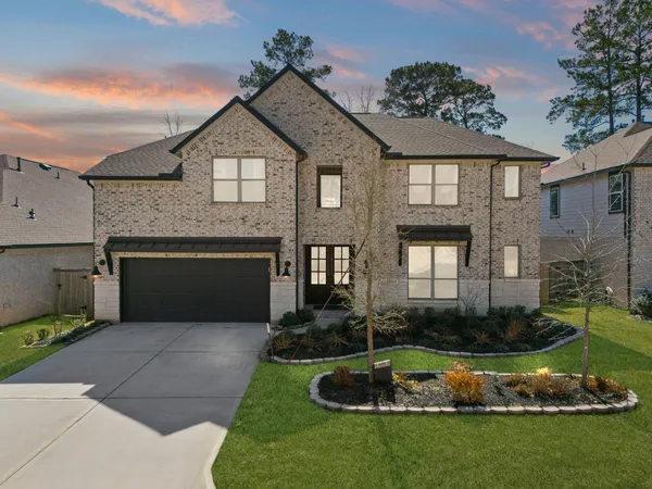 a front view of a house with a garden and plants