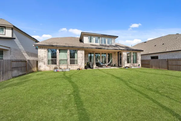 a view of a backyard with table and chairs and wooden fence
