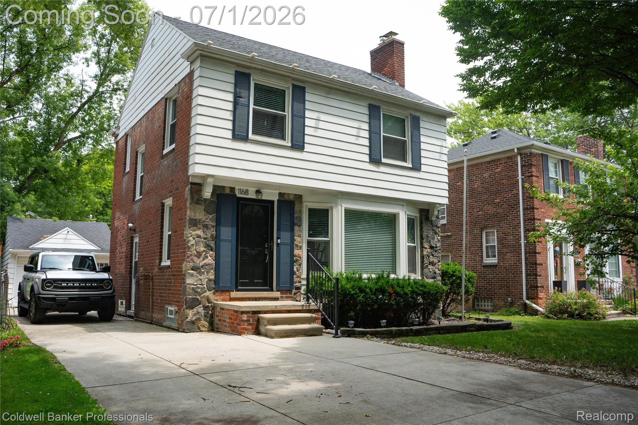1168 Vernier Road Grosse Pointe, MI 48236 - Photo 3 of 32 Two-story residence featuring a brick and stone facade, horizontal white siding, and a gabled roof