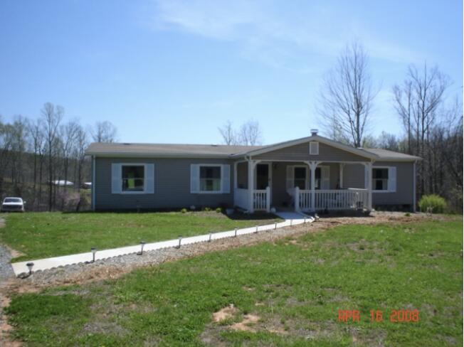 a front view of a house with a garden and trees