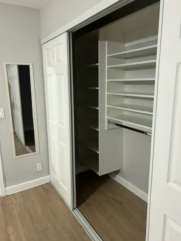 a view of walk in closet with empty racks
