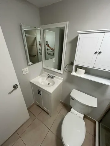 a bathroom with a toilet sink and mirror