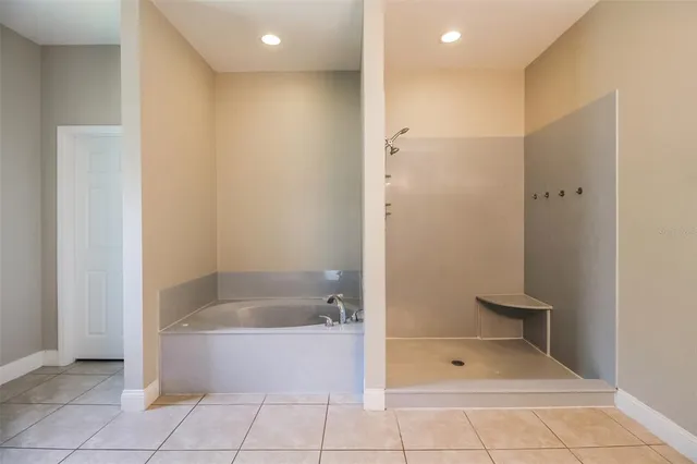 a spacious bathroom with a granite countertop sink a toilet mirror and shower