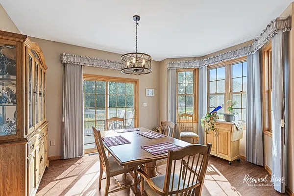 a view of a dining room with furniture large windows and wooden floor