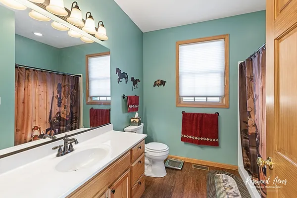 a bathroom with a sink a toilet and mirror