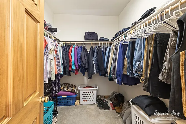 a view of walk in closet with clothes and shoes