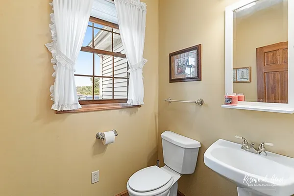 a bathroom with a sink mirror and toilet
