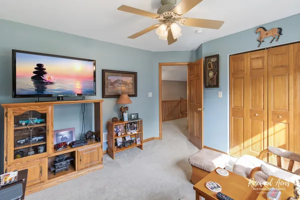 a bedroom with furniture and a chandelier fan
