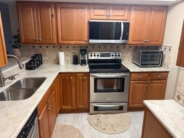 a kitchen with a stove a sink and a microwave