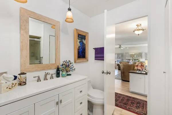 a en suite bathroom with a granite countertop sink and a mirror