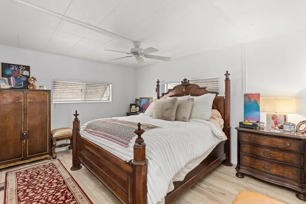 a bedroom with bed and wooden floor