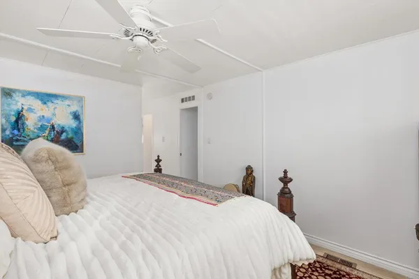 a bedroom with a bed and a painting on the wall