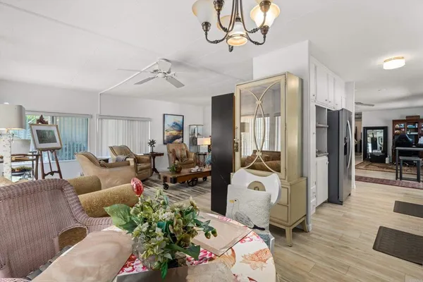 a living room with furniture chandelier and wooden floor