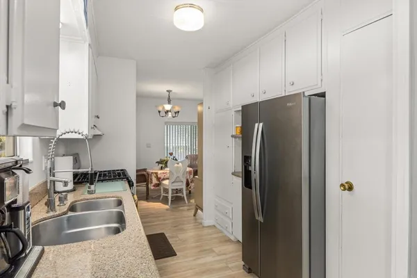 a kitchen with stainless steel appliances granite countertop a refrigerator and a sink