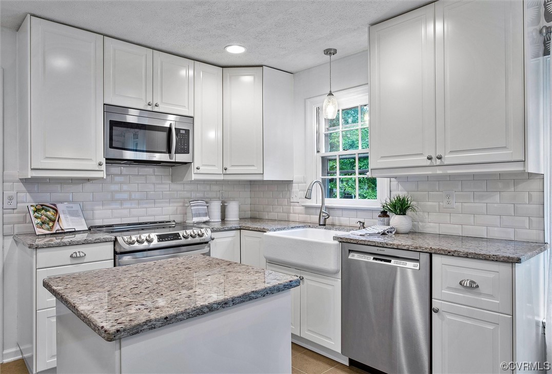 2301 Winterfield Road Midlothian, VA 23113 - Photo 23 of 50 a kitchen with stainless steel appliances granite countertop a sink stove microwave and cabinets
