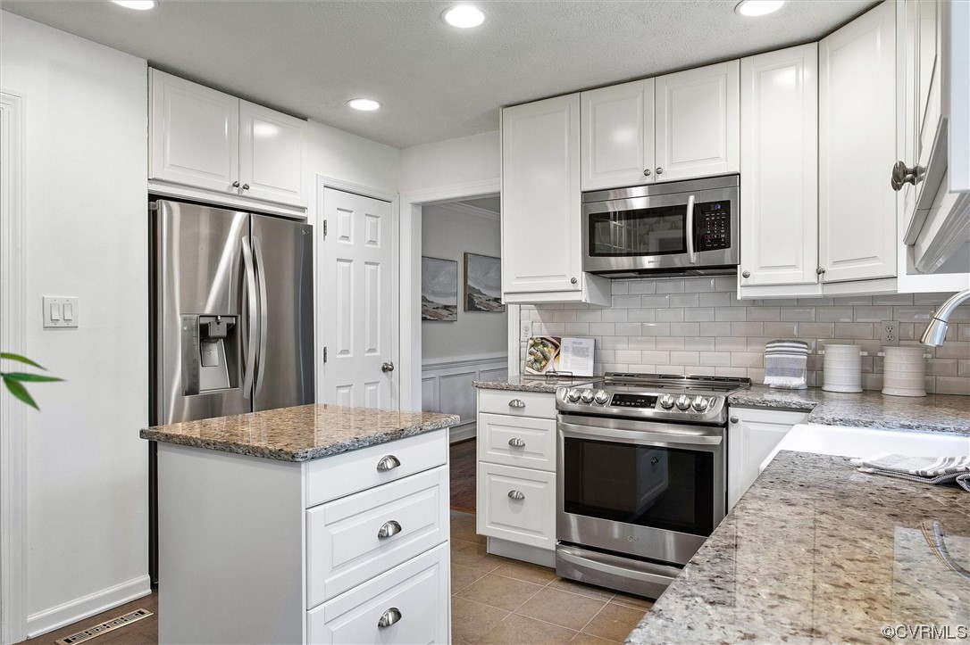 2301 Winterfield Road Midlothian, VA 23113 - Photo 25 of 50 a kitchen with white cabinets and stainless steel appliances