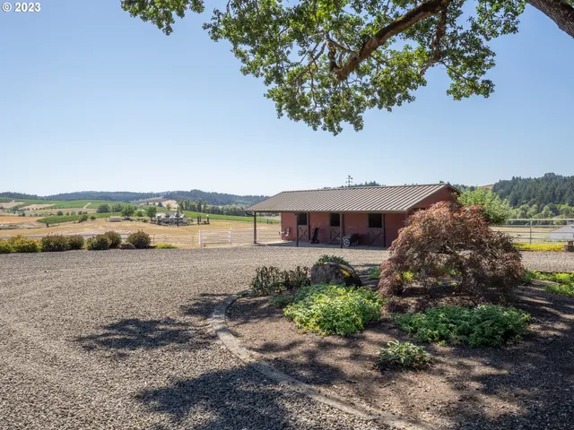 a front view of a house with a garden and trees