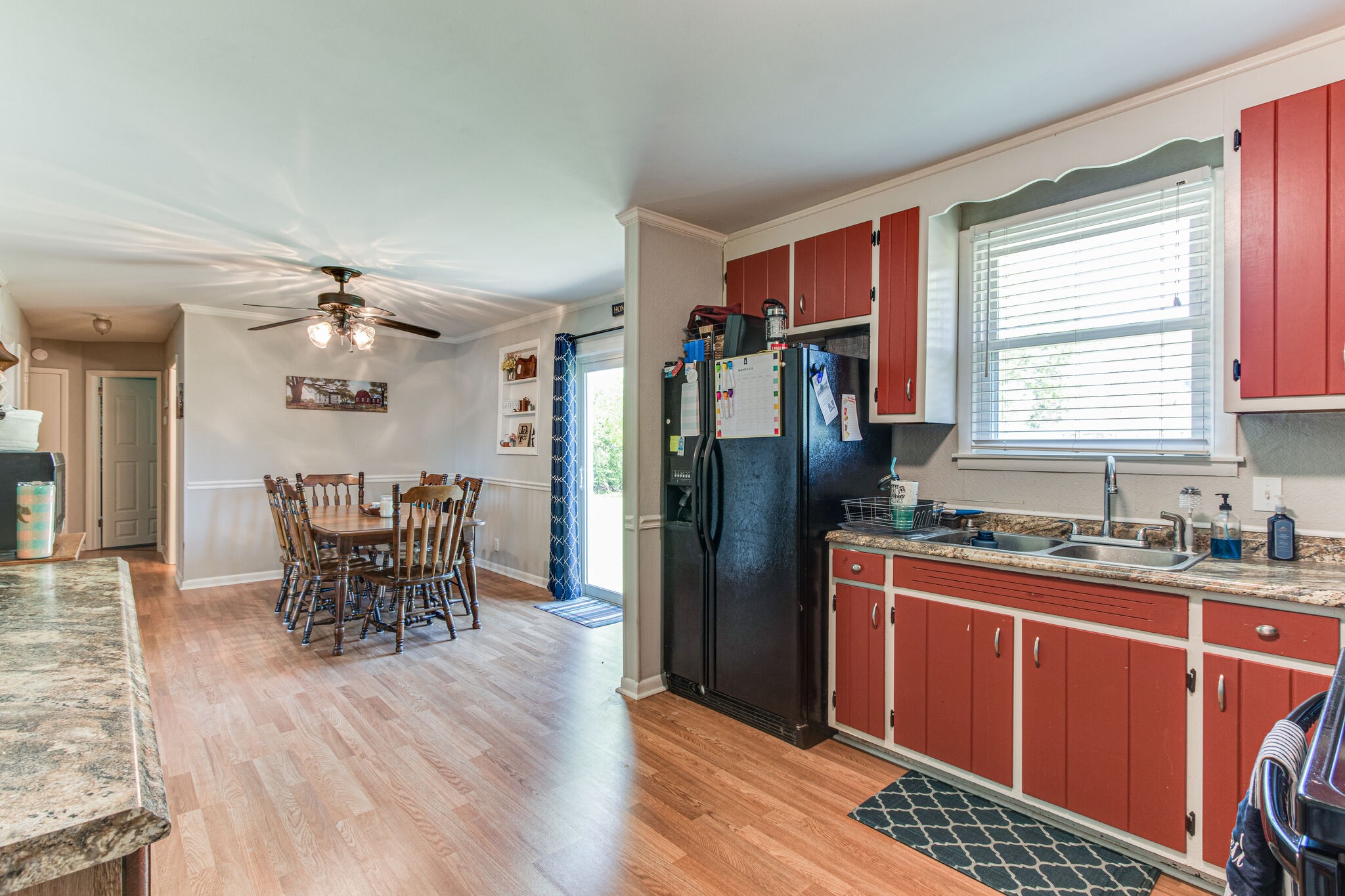 2234 South Ranch Road Murfreesboro, TN 37129 - Photo 13 of 29 a kitchen with stainless steel appliances granite countertop a refrigerator a sink dishwasher a dining table and chairs with wooden floor