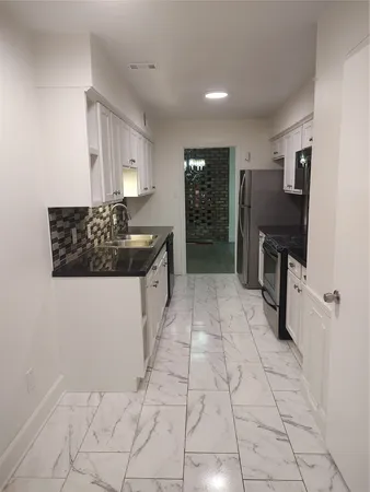 a kitchen with stainless steel appliances a sink stove and cabinets